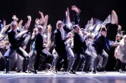 motion-blurred photo of several dancers on stage approaching camera